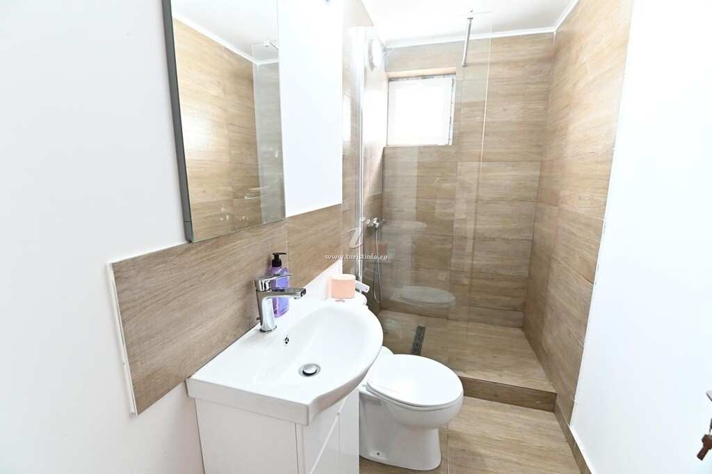 Private bathroom with shower and wood-effect tiles