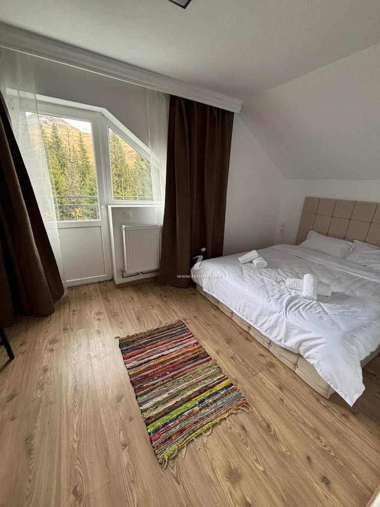 Attic room with a double bed and a balcony door