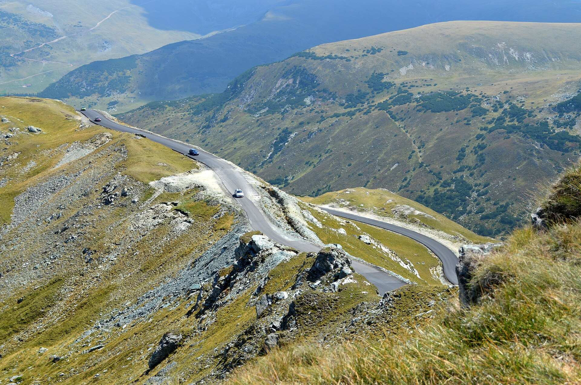 Transalpina hairpins running down a grassy ridge